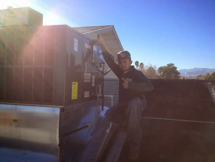 HVAC technician performing Air Duct Cleaning on a rooftop unit in Hyde Park